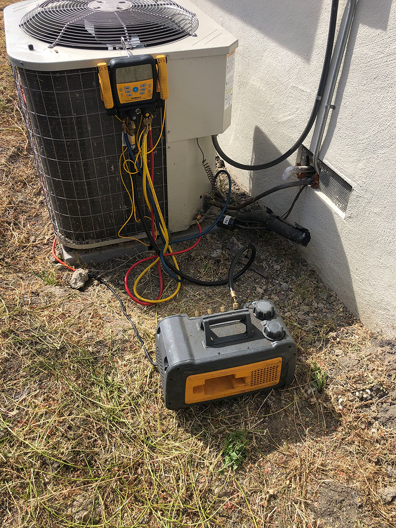 residential outdoor air conditioning condenser unit undergoing maintenance